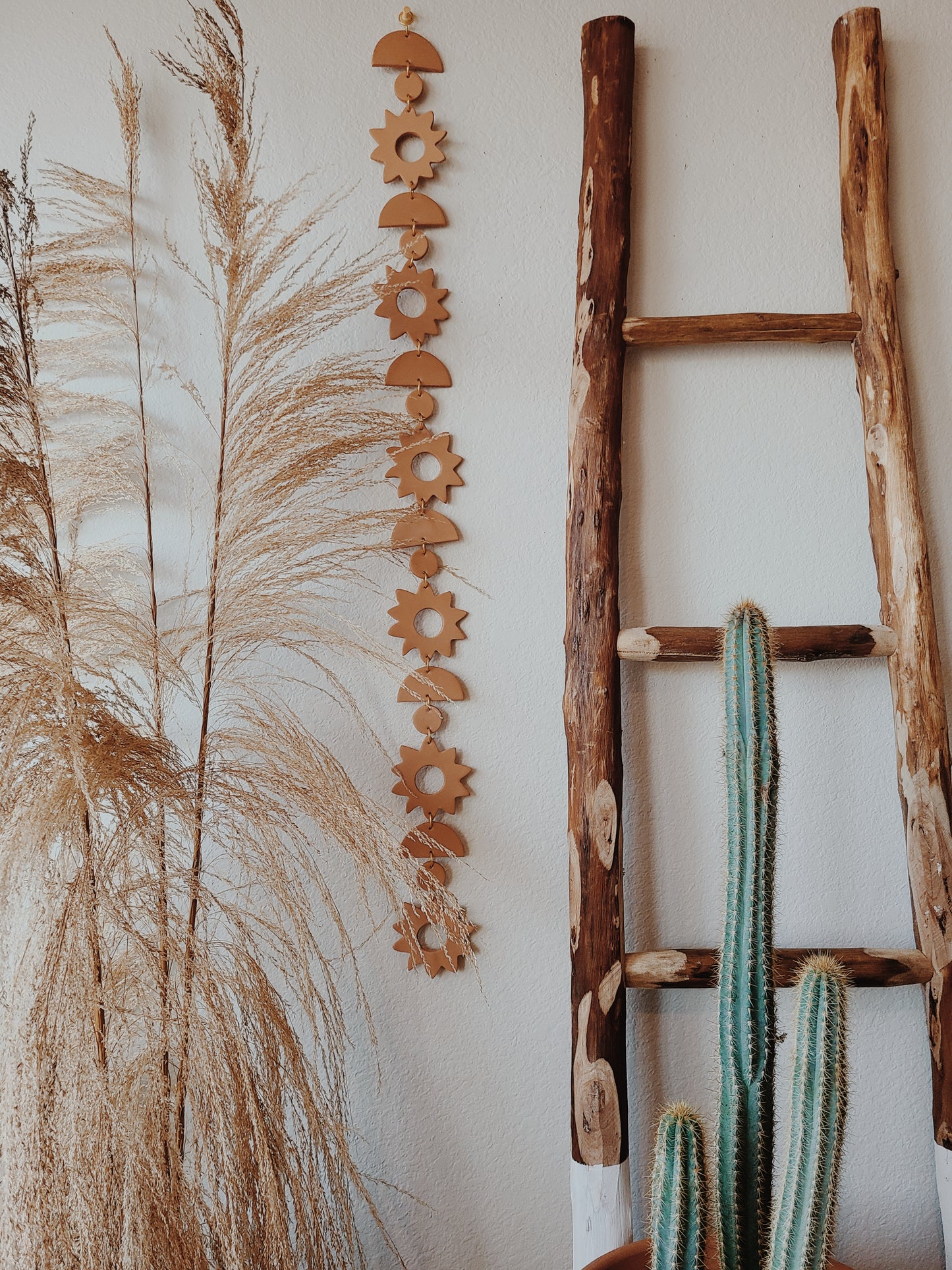 Styled with home decor details like a ladder, cactus, and dried pampas grass this design is sure to stand out with positive energy. 